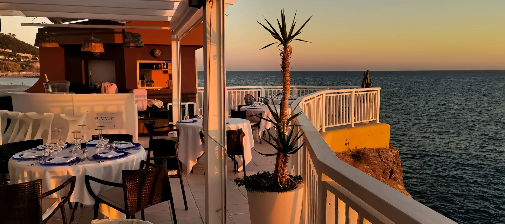 Tavoli preparati per la cena al tramonto in veranda nel ristorante demo Azzurro di Mare